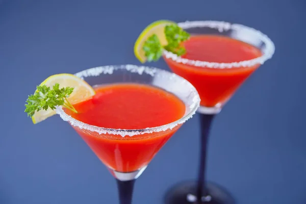 Bloody Mary Cocktail in glasses. Tomato Bloody Mary spicy drink on blue background. — Stock Photo, Image