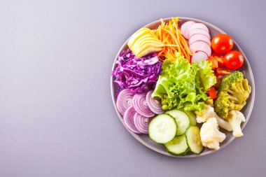 Quinoa, kırmızı lahana, domates, soğan, yeşil salata, gri arka plan üzerinde salatalık ile Sağlıklı sebze buda kase öğle yemeği. Üst te. Kopyalama alanı.
