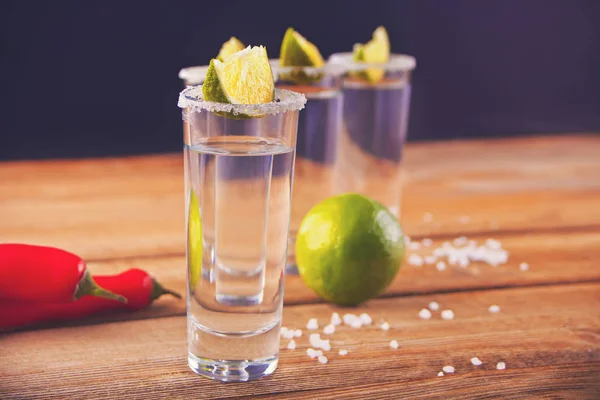 Tequila strzał z wapna i soli morskiej na drewnianym stole — Zdjęcie stockowe