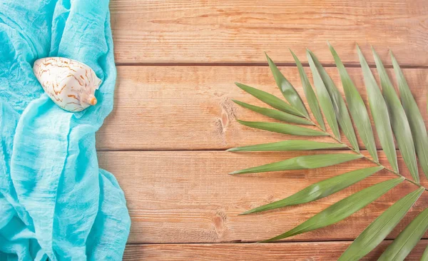 Ahşap arka plan üzerinde tropikal egzotik palmiye yaprakları, mavi bez ve deniz kabuğu. Kopya alanı. Üstte görüntü.