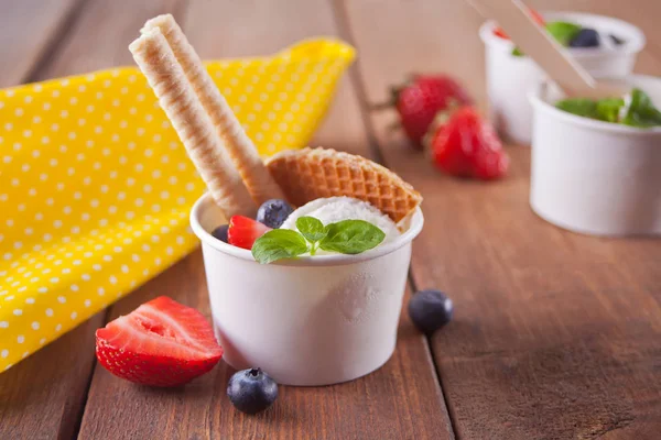 Vanilleeis mit Waffeln, Minzblättern, Erdbeeren und Blaubeeren auf dem Holztisch — Stockfoto