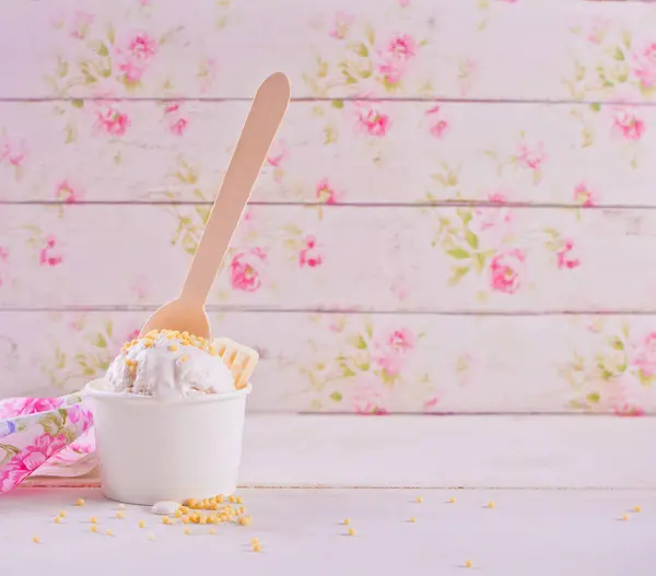 Lody waniliowe z białą czekoladą na białym stole i kwiatowym tle. Kopiuj przestrzeń. — Zdjęcie stockowe