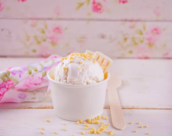 Gelato alla vaniglia con cioccolato bianco sul tavolo bianco e sfondo floreale . — Foto Stock