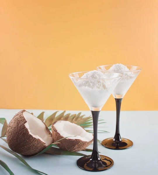 Kokoseis auf blauem und orangefarbenem Hintergrund mit Palmblatt und Kokosnuss — Stockfoto