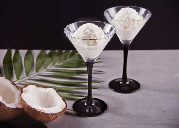 Coconut ice cream on the gray background with palm leaf and coconut