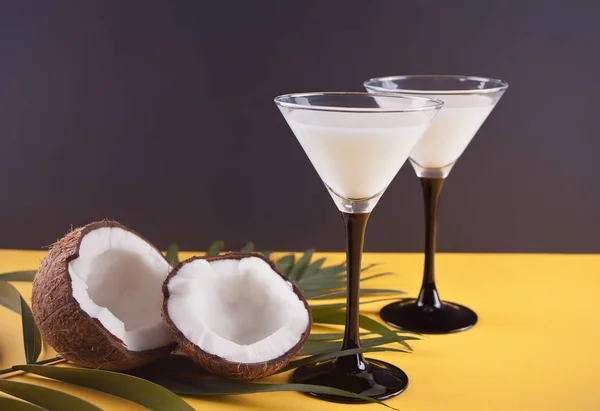 Pina Colada Cocktail auf dem gelben Tisch mit Palmblatt und Kokosnuss auf dem Hintergrund — Stockfoto