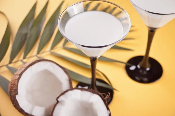 Coquetel Pina Colada na mesa amarela com folha de palmeira e coco no fundo — Fotografia de Stock