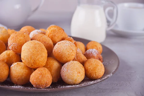 Small balls of freshly baked homemade cottage cheese doughnuts in a plate on a gray background. — Stock Photo, Image