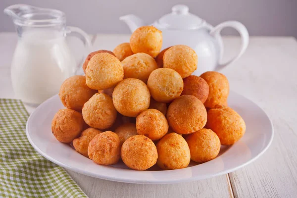 Pequeñas bolitas de donas caseras de requesón recién horneadas en un plato sobre un fondo blanco . —  Fotos de Stock