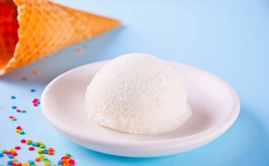 Mavi arka plan üzerinde waffle konileri ve şeker ile Vanilyalı dondurma