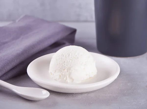 Παγωτό σε λευκή κεραμική πλάκα με γκρίζα πετσέτα και γκρι κούπα σε γκρίζο τραπέζι — Φωτογραφία Αρχείου