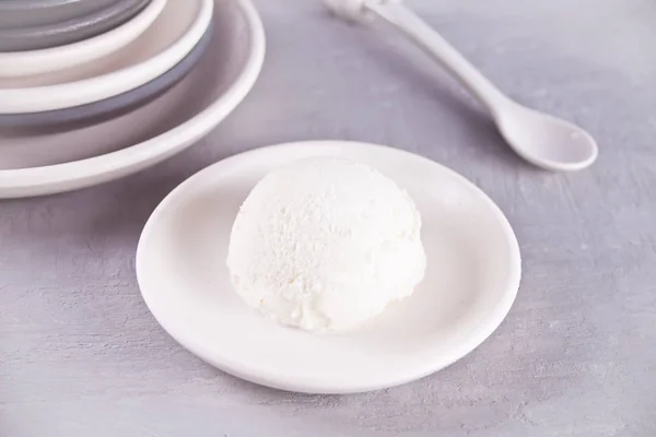 Glass på en vit keramisk tallrik med grå servett och grå och vita tallrikar på ett grått bord — Stockfoto