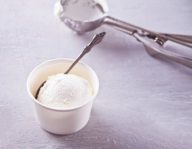 Gri peçete li dondurmalı kağıt kase ve gri bir masa nın üzerine