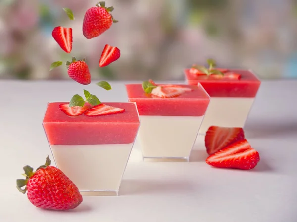 Dessert Panna Cotta mit frischen fliegenden Erdbeeren auf Naturhintergrund — Stockfoto