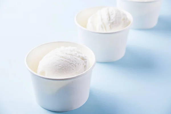 Řada vanilkové zmrzliny na modrém pozadí — Stock fotografie