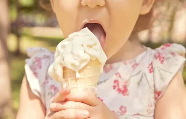 Маленькая девочка ест мороженое. Смешной ребенок с мороженым на открытом воздухе . — стоковое фото