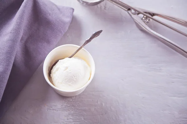 Tigela de papel com sorvete com guardanapo cinza e em uma mesa cinza — Fotografia de Stock