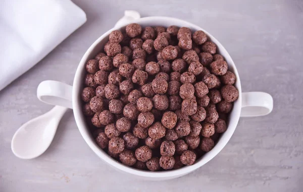 Uma tigela de bolas de chocolate seco cereal na mesa cinza para o café da manhã saudável — Fotografia de Stock