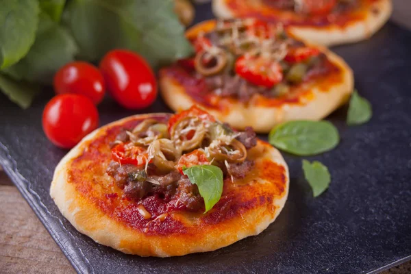 Mini pizza casera en el plato negro — Foto de Stock