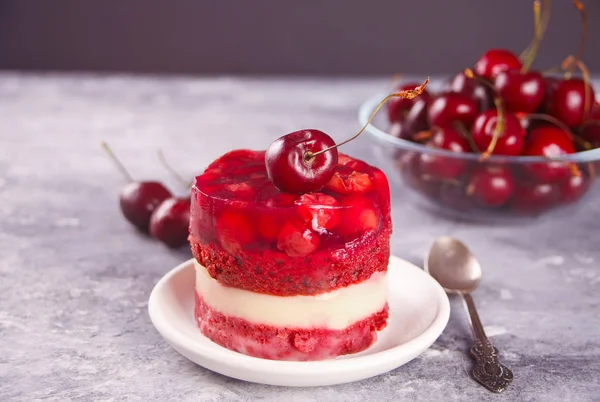 Homemade cherry cake with vanilla cream and cherry jelly on the gray background — Stock Photo, Image