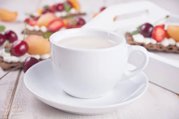 Чашка чая и хлеба со сливочным сыром, фруктами и ягодами — стоковое фото