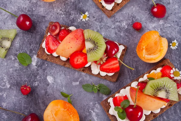 Pão crocante com creme de queijo, frutas e bagas — Fotografia de Stock