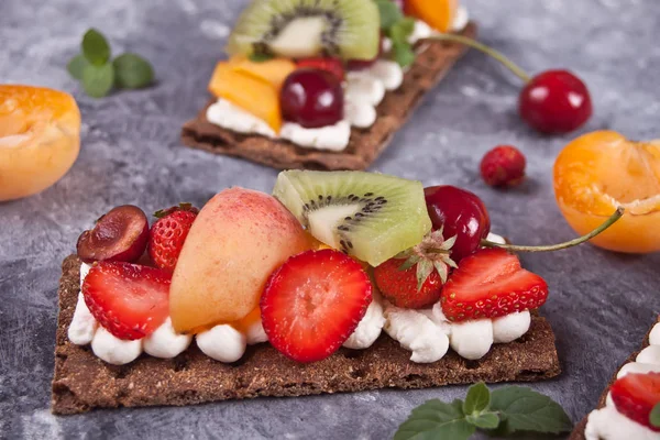 Pão crocante com creme de queijo, frutas e bagas — Fotografia de Stock