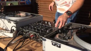 Erkek elleri bir plak çıtası açıyor. Pikapta vinil kayıt. Adam ses konsolu knobs yukarı çekerek