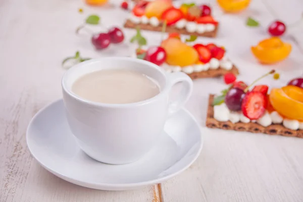 Cup of tea and crisp bread with creme cheese, fruit and berries — Stock Photo, Image