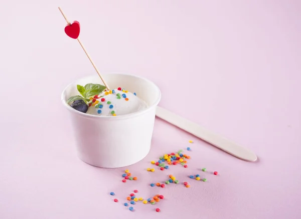 Vanilla ice cream with mint leaf, strawberries and blueberries on the pink background — Stock Photo, Image