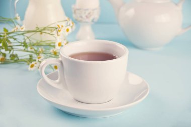 Sabah. Kahvaltı. Sütlü çay, sütlü kavanoz, mavi arka planda yumurta