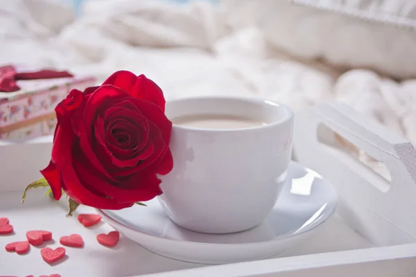 Закрываем чашку чая с красной розой и маленькими свежими сердцами на столе — стоковое фото