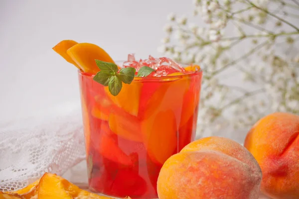 Стекло со свежим домашним персиком сладкий чай со льдом или коктейль, лимонад с мятой. Освежающий холодный напиток. Летняя вечеринка . — стоковое фото