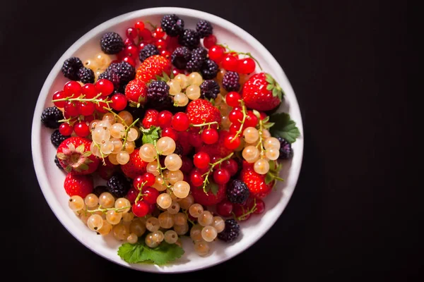 Gesunde Mischbeere mit Erdbeere, Brombeere, roter und weißer Johannisbeere auf schwarzem Hintergrund. Ansicht von oben. Kopierraum. — Stockfoto