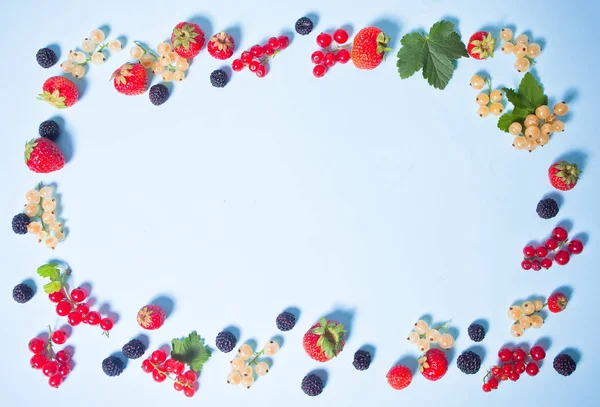 Farbenfroher Rahmen mit Brombeere, Erdbeere, roter und weißer Johannisbeere auf blauem Hintergrund. flach lag. Ansicht von oben. — Stockfoto