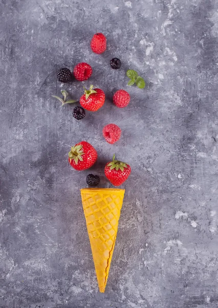 Strawberriess en gofre cono amarillo sobre un fondo de concrear . — Foto de Stock