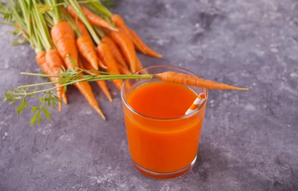 Carrot juice in glass on concrete background — Stock Photo, Image