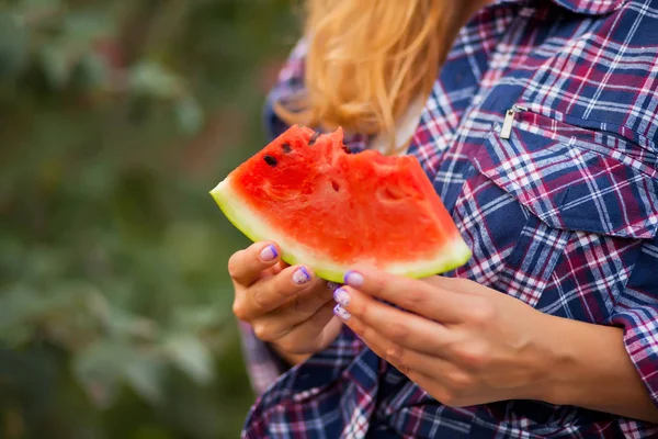 Piknikte elinde olgun karpuz parçası olan bir kadın. Sonbahar hasadı. Sonbahar konsepti