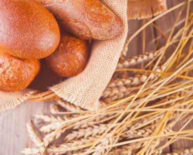 taze pişmiş çavdar ekmeği ile tahıl ve tohum sepet ve buğday ahşap mutfak masasına kaynaklanıyor. Üst te. Kopyalama alanı.