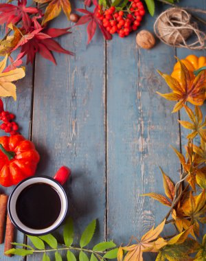 Eski mavi ahşap masada sonbahar yaprakları ve küçük kabaklar ile kahve fincan. Sonbahar hasadı. Sonbahar konsepti.