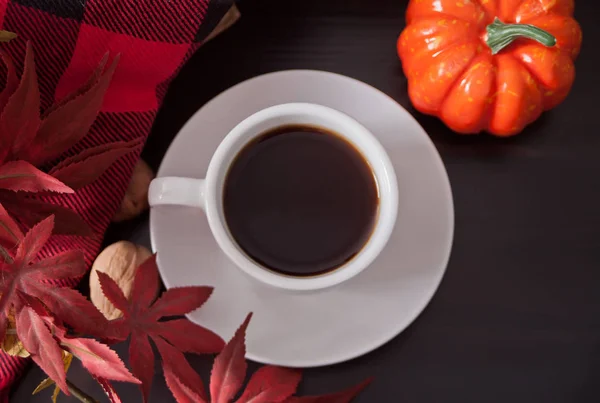 Cup of coffee with autumn leaves. pumpkin on the dark table. Autumn harvest. Autumn concept. Top view.