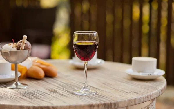Üveg vörösbor az asztalon egy szabadtéri kávézóban — Stock Fotó