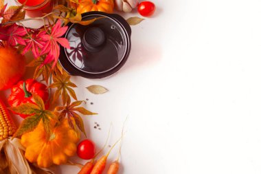 Siyah tava, sonbahar yaprakları, kabak ve beyaz arka plan üzerinde sebze. Sonbahar hasadı. Sonbahar yemekleri. Üst te. Kopyalama alanı