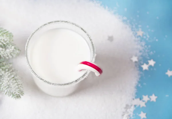 一杯牛奶，糖果甘蔗，蓝色背景上的圣诞树树枝 — 图库照片