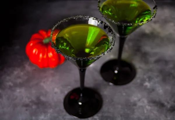 Два стакана с зеленым коктейлем для Хэллоуина на сером фоне — стоковое фото