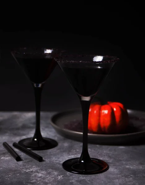Dos vasos con cóctel negro, rosas secas, calabaza para la fiesta de Halloween en el fondo oscuro — Foto de Stock