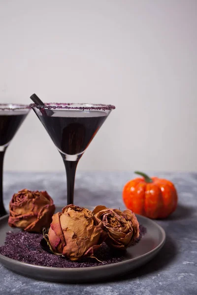 Zwei Gläser mit schwarzem Cocktail, getrockneten Rosen, Kürbis für die Halloween-Party auf dunklem Hintergrund — Stockfoto