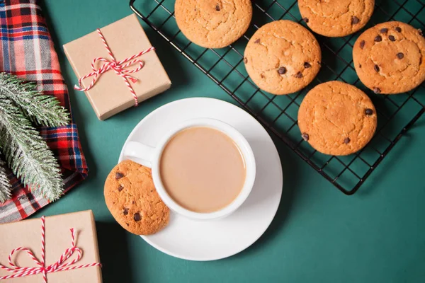 Cup of tea, homemade cookie, Christmas gift boxes and Christmas decor on the green background. — Stock Photo, Image