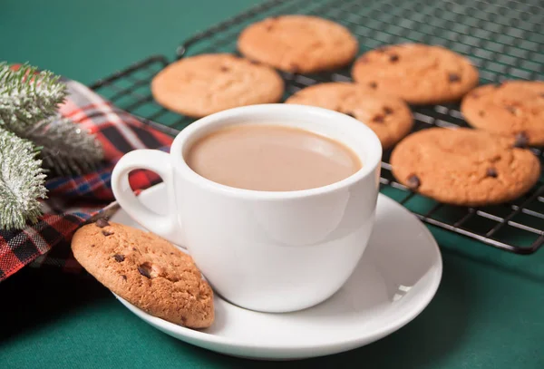 Cup of tea, homemade cookie, Christmas gift boxes and Christmas decor on the green background. — Stock Photo, Image