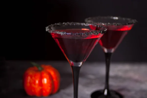 Dos vasos con cóctel rojo, rosas secas para la fiesta de Halloween en el fondo oscuro — Foto de Stock